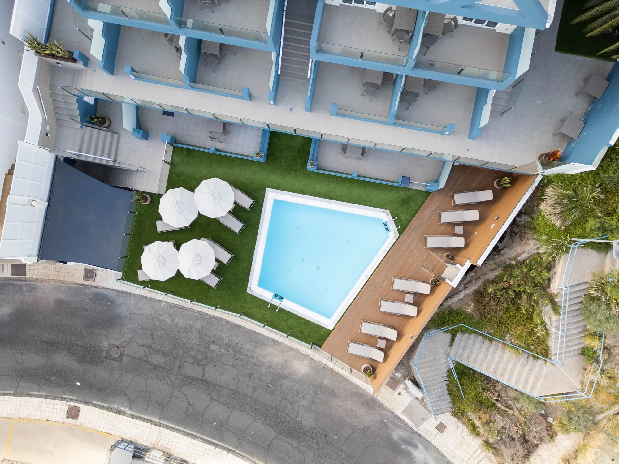 Top-down view of the pentagon pool, parasols, loungers and lawn