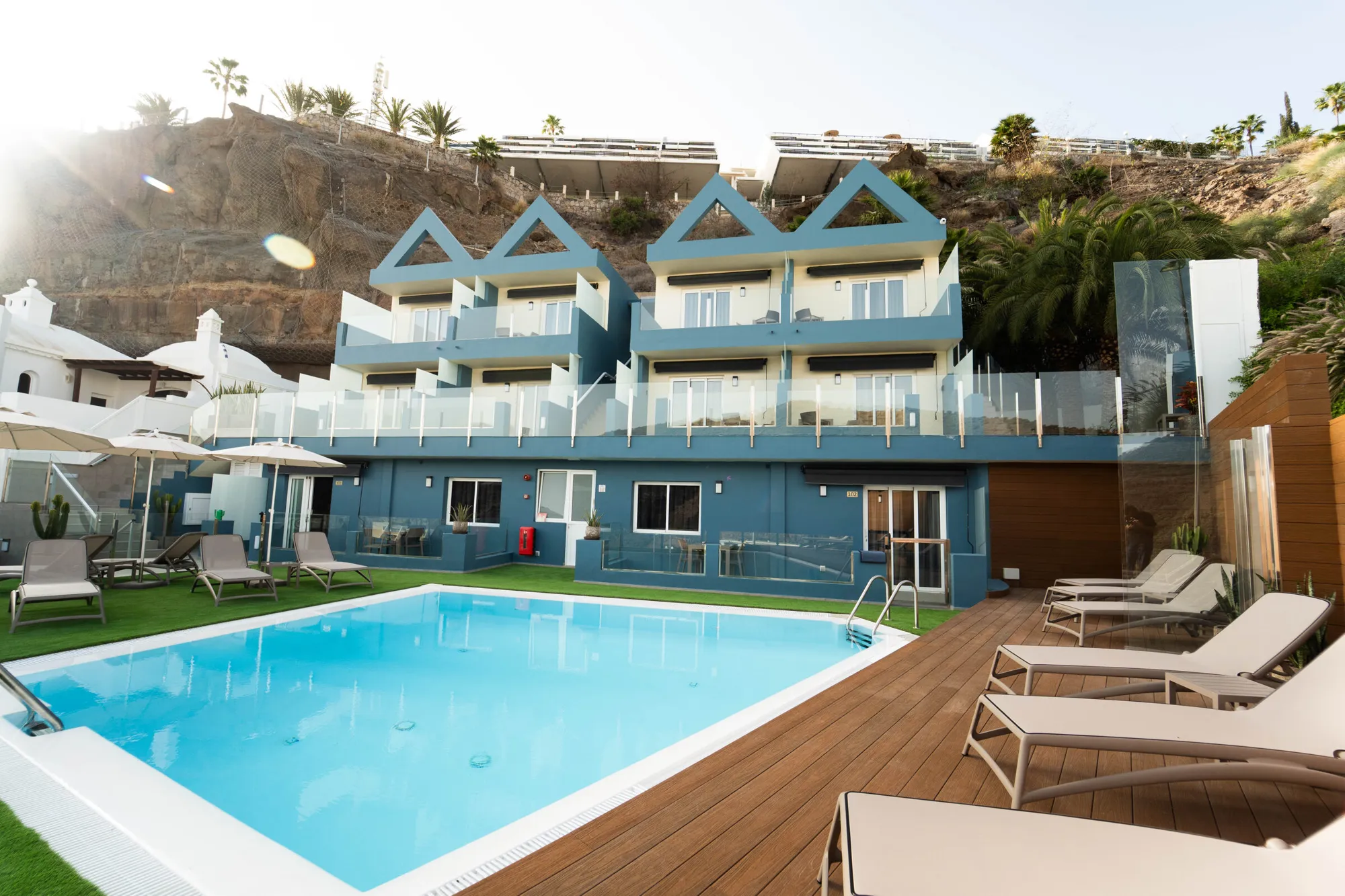 Golden evening light on the pool, with The Hive and the cliffs behind