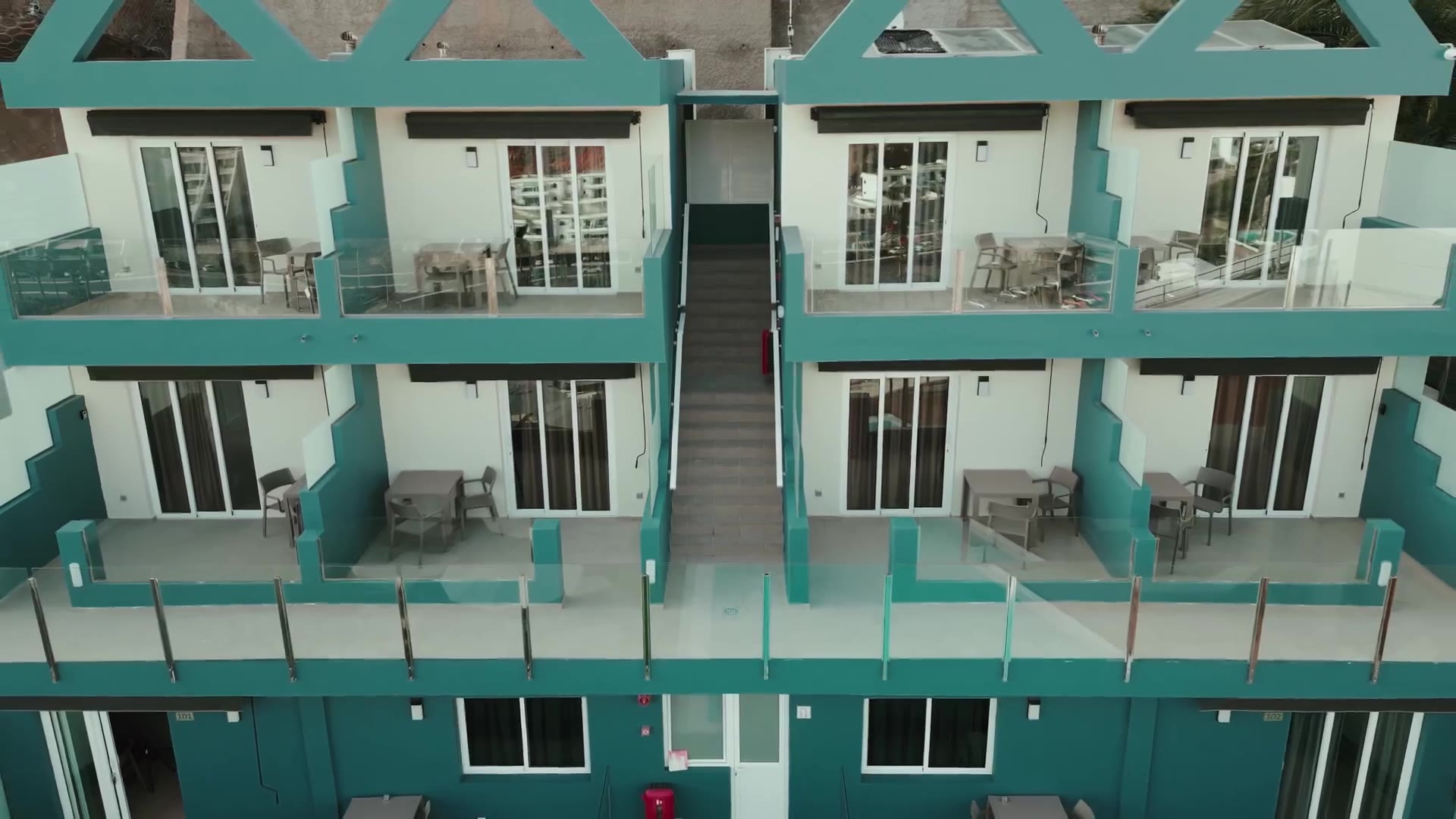 Drone film of The Hive's blue gabled building and pentagon pool